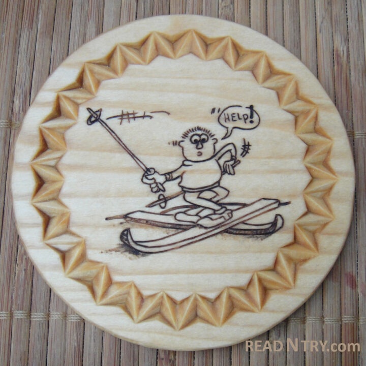 A round coaster with a chip carved border and a burned skier in a comic position. The sketch of the confused skier comes from the “Mark Kistler’s Draw Squad” book.