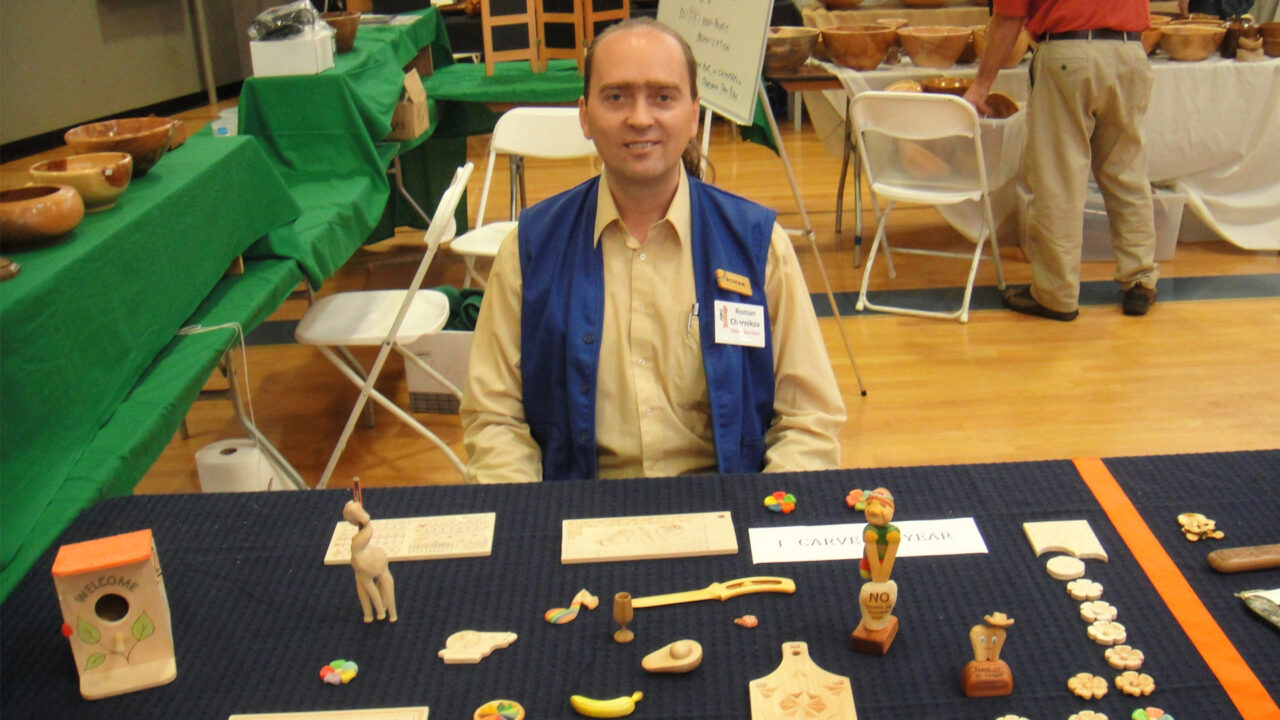 Roman is at his table, presenting his woodcarving projects at the SCVC woodcarving show.