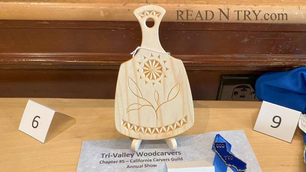 Chip carved serving board is 6" (16 cm) long along with the blue pin award during Tri-Valley Woodcarving Show, 2024