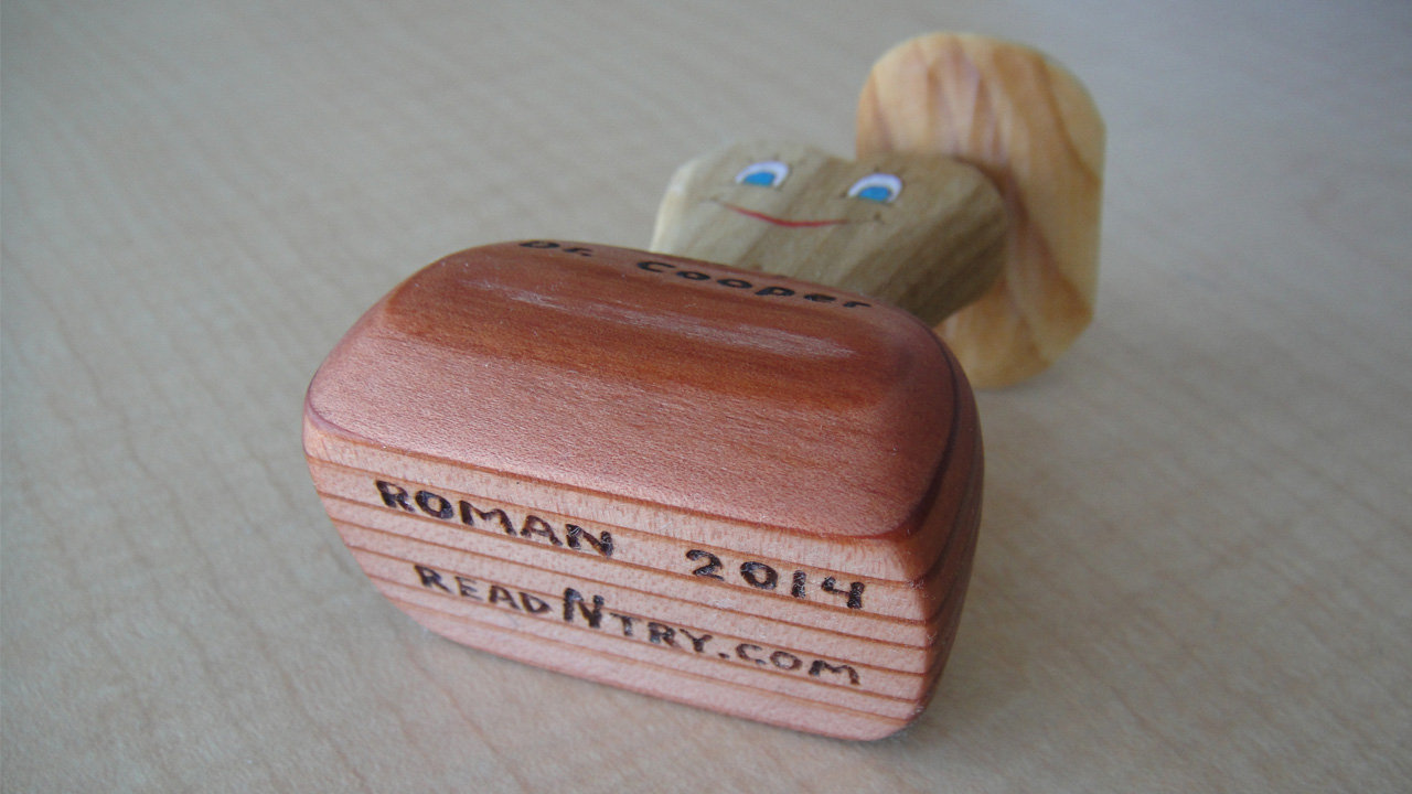 A bottom view of the three-piece woodcarving gift for a dentist: a molar tooth in a cowboy hat. The base was signed and dated.