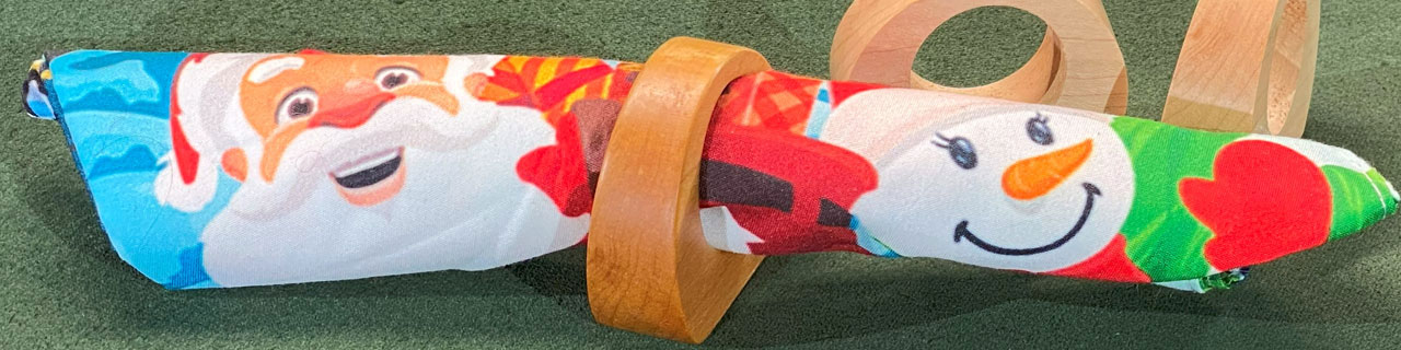 Winter holiday themed napkin in a turned maple napkin ring.